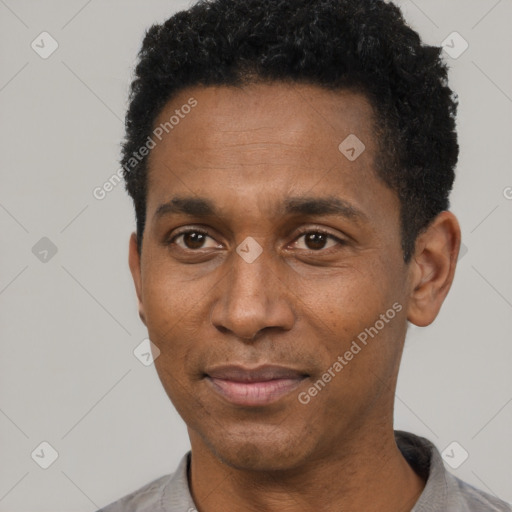 Joyful black adult male with short  black hair and brown eyes