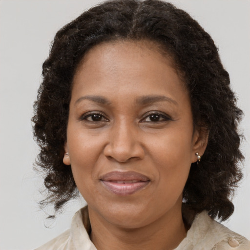Joyful black adult female with medium  brown hair and brown eyes