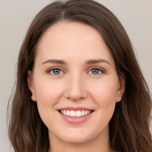 Joyful white young-adult female with long  brown hair and grey eyes