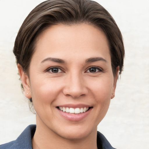 Joyful white young-adult female with short  brown hair and grey eyes