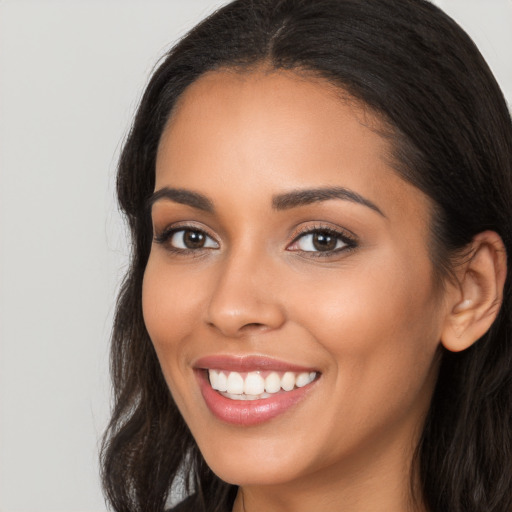 Joyful latino young-adult female with long  brown hair and brown eyes