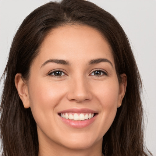 Joyful white young-adult female with long  brown hair and brown eyes