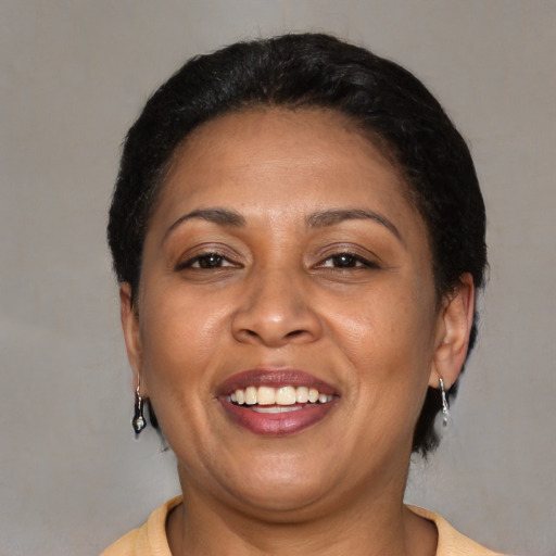Joyful latino adult female with short  brown hair and brown eyes