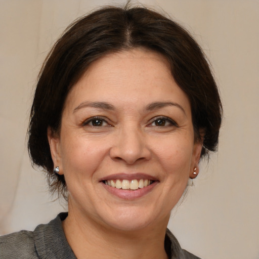 Joyful white adult female with medium  brown hair and brown eyes