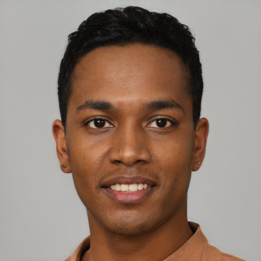 Joyful black young-adult male with short  black hair and brown eyes