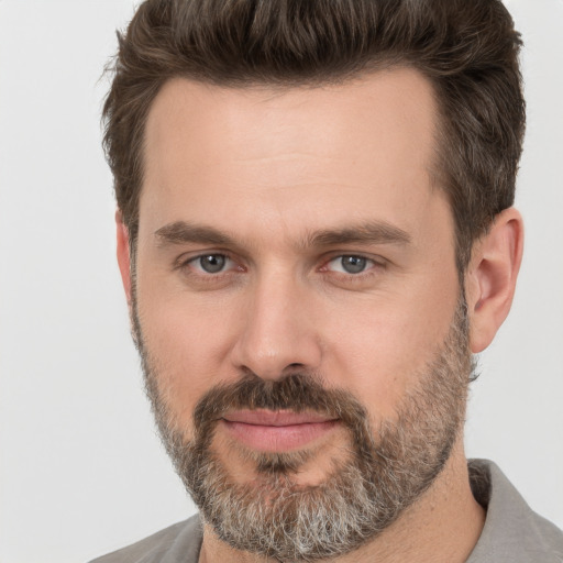 Joyful white adult male with short  brown hair and brown eyes