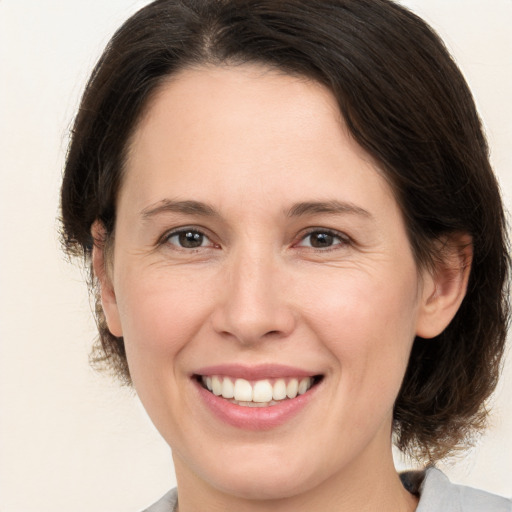 Joyful white adult female with medium  brown hair and brown eyes