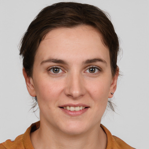 Joyful white young-adult female with medium  brown hair and grey eyes