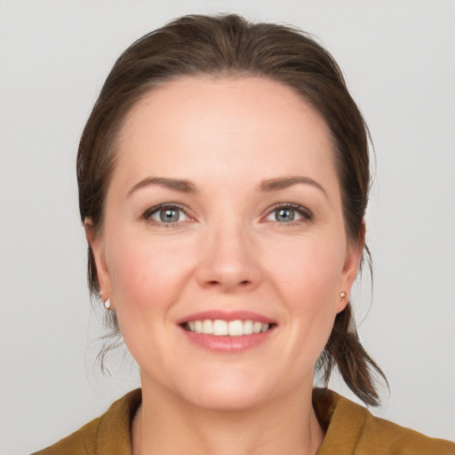 Joyful white young-adult female with medium  brown hair and grey eyes