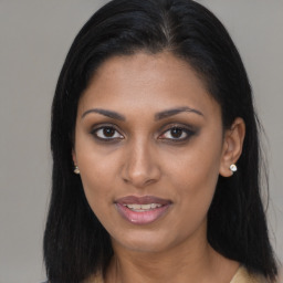 Joyful black young-adult female with long  brown hair and brown eyes