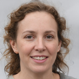 Joyful white adult female with medium  brown hair and blue eyes