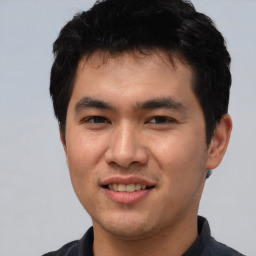 Joyful asian young-adult male with short  black hair and brown eyes