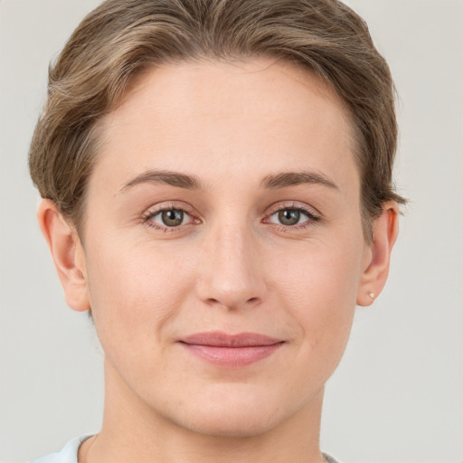 Joyful white young-adult female with short  brown hair and grey eyes