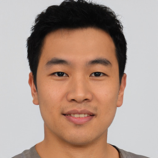 Joyful asian young-adult male with short  brown hair and brown eyes