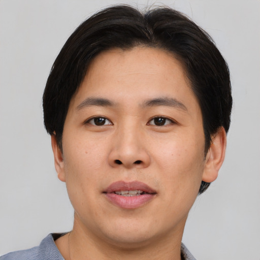Joyful asian young-adult male with short  brown hair and brown eyes