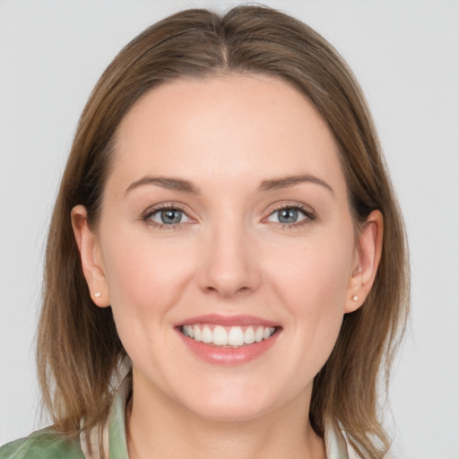 Joyful white young-adult female with medium  brown hair and grey eyes