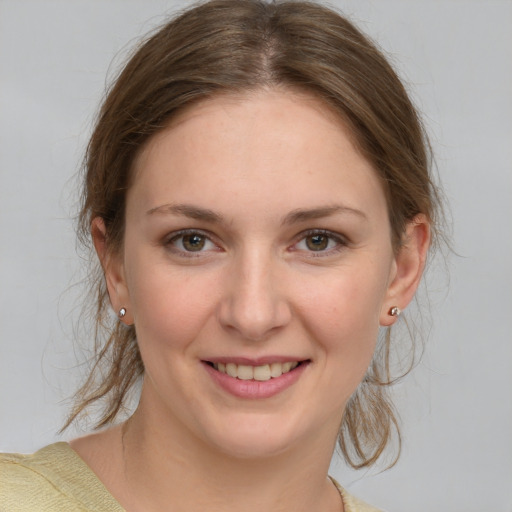 Joyful white young-adult female with medium  brown hair and grey eyes