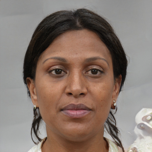 Joyful black adult female with medium  brown hair and brown eyes