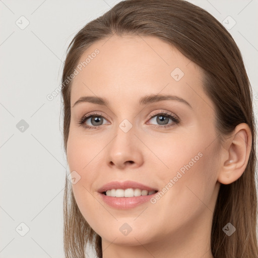 Joyful white young-adult female with long  brown hair and grey eyes