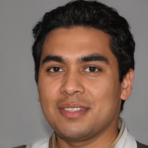 Joyful latino young-adult male with short  black hair and brown eyes