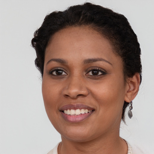 Joyful black young-adult female with short  brown hair and brown eyes