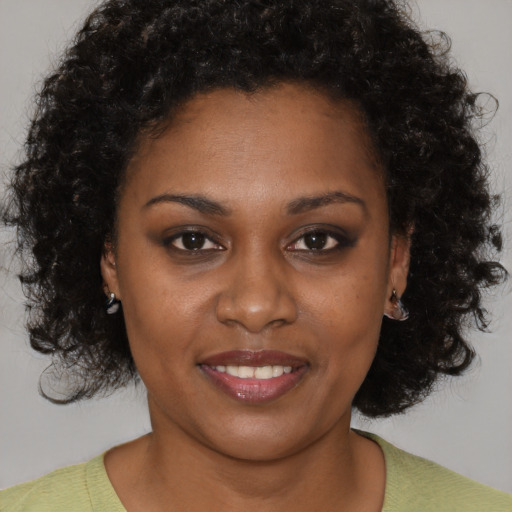 Joyful black young-adult female with short  brown hair and brown eyes