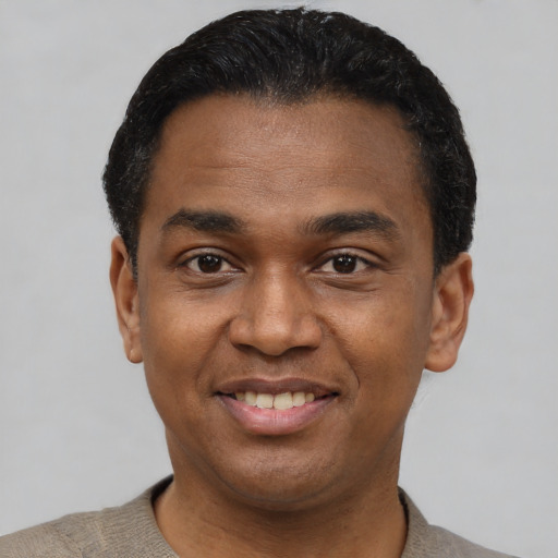 Joyful latino young-adult male with short  black hair and brown eyes
