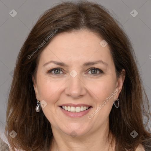 Joyful white adult female with long  brown hair and grey eyes