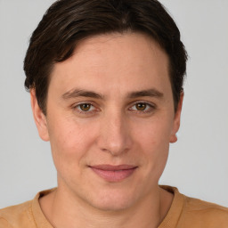 Joyful white young-adult male with short  brown hair and grey eyes