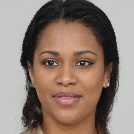Joyful black young-adult female with long  brown hair and brown eyes