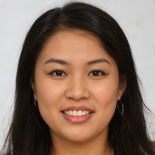 Joyful latino young-adult female with long  brown hair and brown eyes