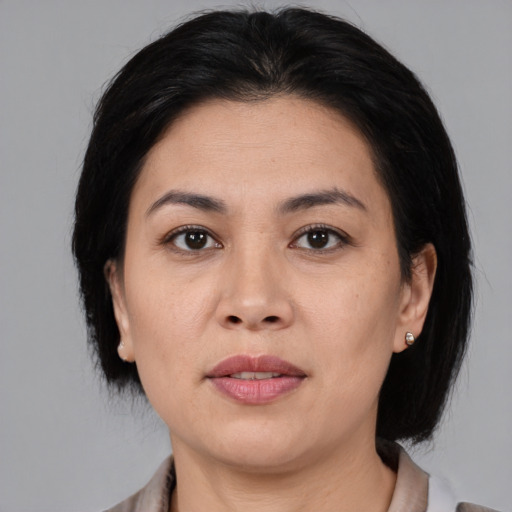 Joyful asian adult female with medium  black hair and brown eyes