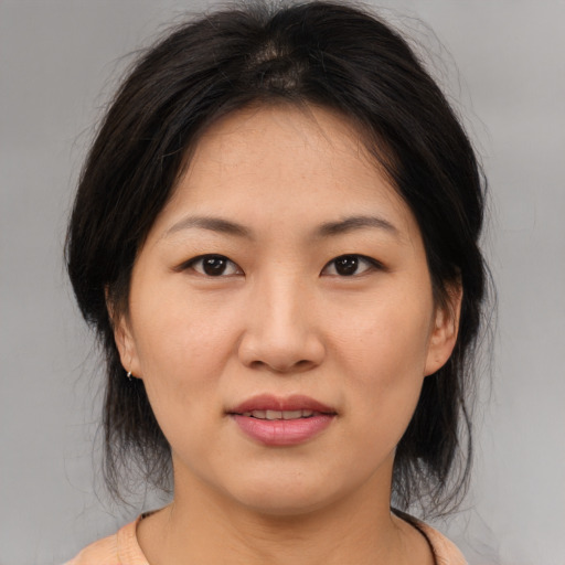 Joyful asian young-adult female with medium  brown hair and brown eyes