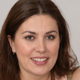 Joyful white adult female with long  brown hair and brown eyes