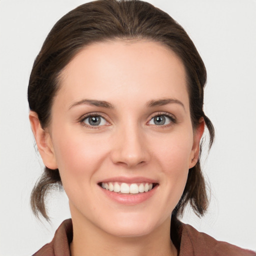 Joyful white young-adult female with medium  brown hair and grey eyes