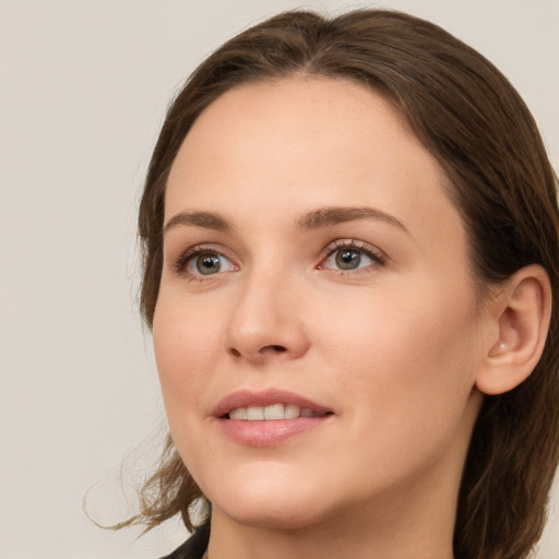 Joyful white young-adult female with medium  brown hair and grey eyes