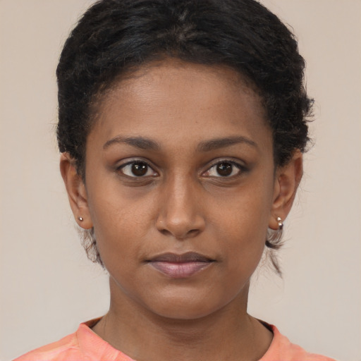 Joyful black young-adult female with short  brown hair and brown eyes