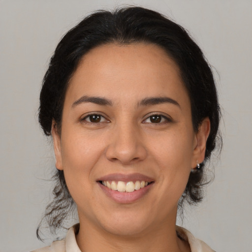 Joyful latino young-adult female with medium  brown hair and brown eyes