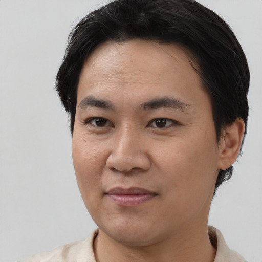 Joyful asian young-adult male with short  black hair and brown eyes