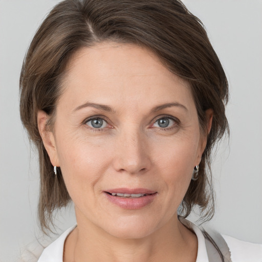 Joyful white adult female with medium  brown hair and grey eyes