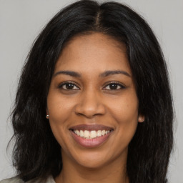 Joyful black young-adult female with long  brown hair and brown eyes