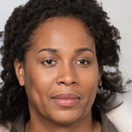 Joyful black adult female with medium  brown hair and brown eyes