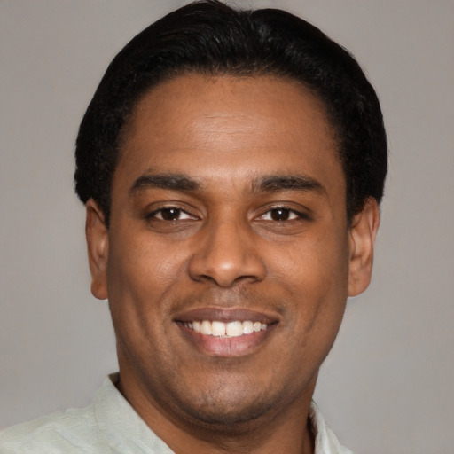 Joyful latino young-adult male with short  black hair and brown eyes