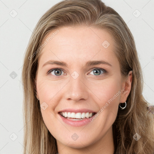 Joyful white young-adult female with long  brown hair and blue eyes