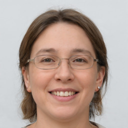 Joyful white adult female with medium  brown hair and grey eyes