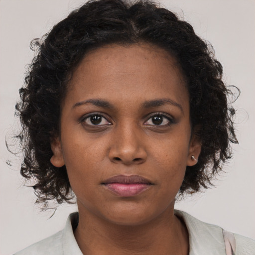 Joyful black young-adult female with long  brown hair and brown eyes