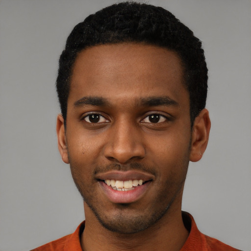 Joyful black young-adult male with short  black hair and brown eyes