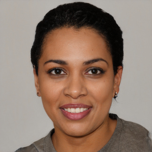 Joyful black young-adult female with short  black hair and brown eyes