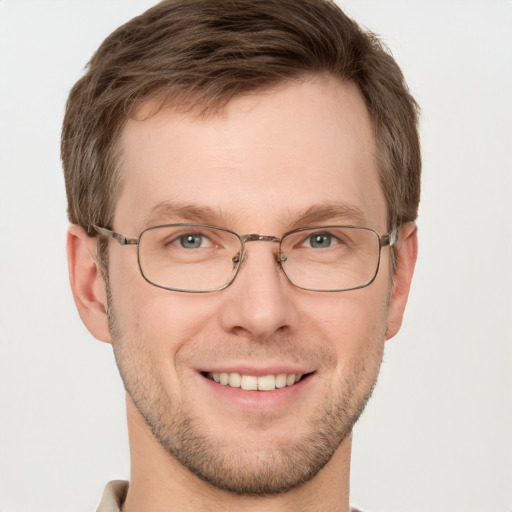 Joyful white young-adult male with short  brown hair and grey eyes