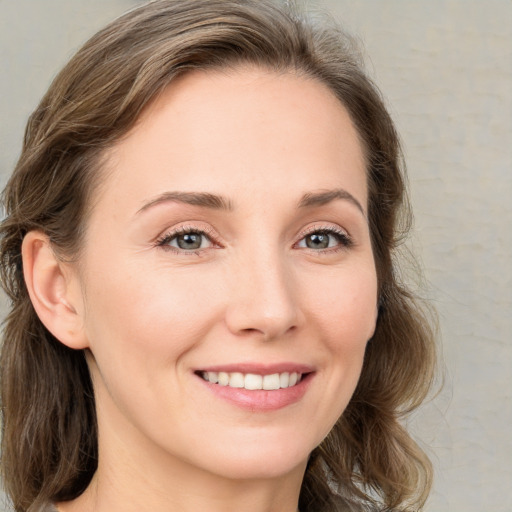 Joyful white young-adult female with medium  brown hair and green eyes